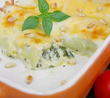 Каннеллони со шпинатом и сыром под блюдом под соусом бешамель